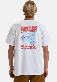Witte katoenen t-shirt met een kleurrafische afbeelding op de achterkant, inclusief het woord "FINZZA", speelse karakters en "Billabong Co." branding.