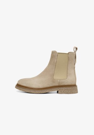 Beige suède Chelsea boot met elastische zijpanelen en een trekhaak. Textuur rubberen zool zorgt voor grip en duurzaamheid. Rond toelopend ontwerp.