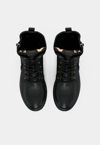 Black leather ankle boots with round toes, lace-up front, and textured interior featuring a leopard print pattern. Side zipper for easy wear.