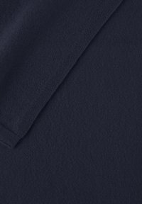 Tissu texturé bleu marine avec une apparence douce et tricotée. Présente une finition lisse et un motif subtil, adapté à diverses applications textiles.