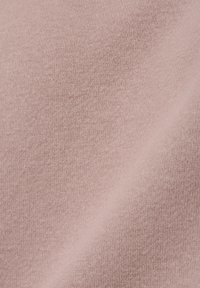 Jasnoróżowa dzianina o miękkiej teksturze, prezentująca delikatny, równomierny wzór. Materiał wydaje się gładki i lekko rozciągliwy.