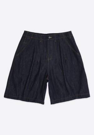 Donkerblauwe denim shorts met zijzakken, lussen voor een riem en een knoopsluiting aan de voorkant, plat neergelegd op een lichte achtergrond.