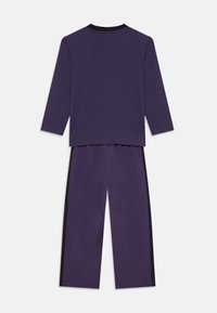 Top de manga larga morado y pantalones a juego, con un escote negro y acentos laterales. Tejido suave con un corte relajado.