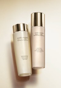 Dos botellas de Estee Lauder: una blanca con una tapa plateada etiquetada como "Optimizing Power" y otra de color rosa pálido con una tapa plateada etiquetada como "Youth Power".