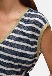 T-shirt rayé avec des rayures horizontales bleu marine et blanches, présentant une texture douce et un accent doré au niveau de l'encolure et des manches.