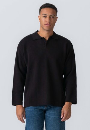 Sort pullover lavet af tykt stof, med krave og lange ærmer. Designet er afslappet med en lige kant, båret med blå jeans.