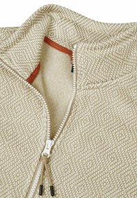 Hellbrauner, gemusterter Fleece-Half-Zip-Pullover mit strukturierter Oberfläche, weißem Reißverschluss und kontrastierender innerer Kragenverkleidung in Orange.