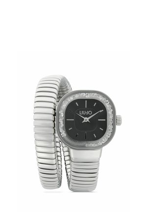 Montre-bracelet Liu Jo ton argent avec cadran carré noir, lunette en cristal, et bracelet métallique flexible en spirale enroulé autour du présentoir.