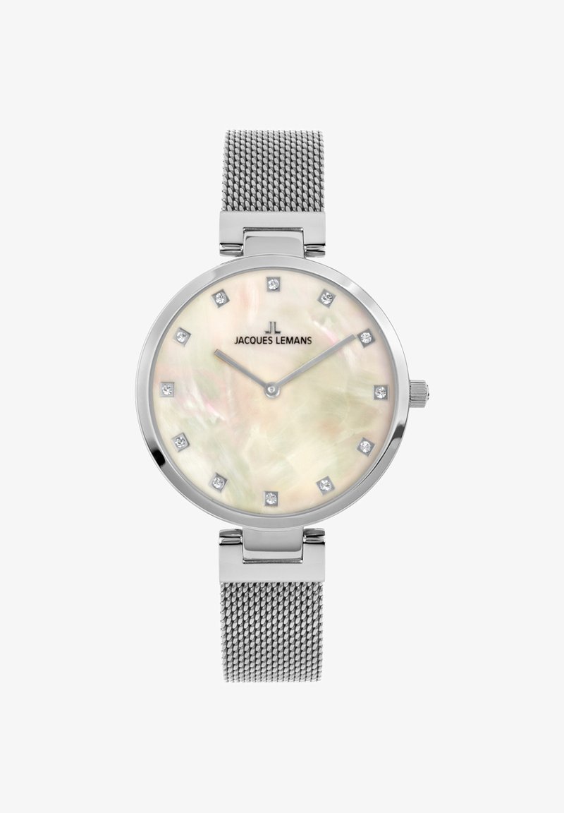 Reloj plateado redondo con correa de malla, que presenta una esfera de nácar, marcadores de hora de diamante y el logotipo de la marca; diseño minimalista.