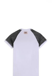 Camiseta blanca con mangas raglán de malla negra. Etiqueta en la parte posterior del cuello. Material de algodón suave y textura lisa en toda la prenda.