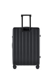 Black spinner suitcase with vertical grooves, retractable handle, two wheels, side carry handle, and smooth textured finish.