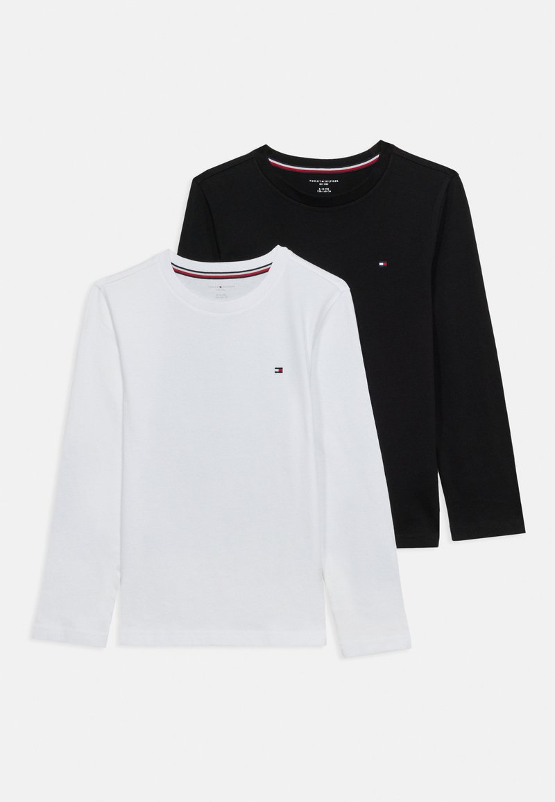 Δύο μπλούζες με μακρύ μανίκι και στρογγυλή λαιμόκοψη σε μαύρο και λευκό, κάθε μία με ένα μικρό λογότυπο σε κόκκινο, λευκό και μπλε στη αριστερή πλευρά του στήθους.