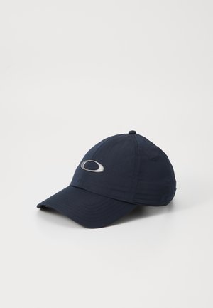 Marineblå baseballcaps laget av stoff, med en buet skjerm, ton i ton- søm og med en sølvfarget logo aksent foran. Teksturert overflate.