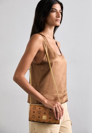 Braune MCM-Handtasche mit Logo-Print, goldener Kettenriemen, rechteckiger Form, aus Leder und mit strukturierter Oberfläche.