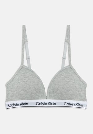 Soutien-gorge Calvin Klein gris clair avec bretelles ajustables et bande élastique blanche avec logo noir de la marque.