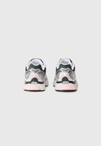 Sport shoes with a black mesh upper, silver accents, pink midsole, and textured sole. Rear view shows padded collar and ventilated design.