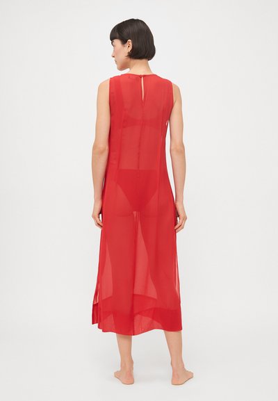 Abito rosso in chiffon con silhouette dritta, design senza maniche, chiusura con apertura a chiave sul retro e orlo che arriva a metà polpaccio.