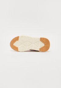 Semelle de chaussure avec une semelle intermédiaire blanche texturée et une semelle extérieure en caoutchouc tan à motifs ; conception de semelle géométrique pour une adhérence et une stabilité accrues.
