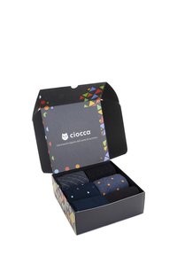 Schwarze Geschenkbox mit bunten geometrischen Mustern; enthält sechs Paar Socken in verschiedenen dunklen Farbtönen und unterschiedlichen Punkt- und Rastermustern.
