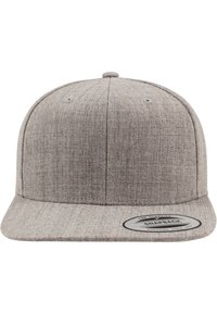 Hallikas snapback müts, mis on valmistatud tekstuursest kangast. Omab tasast ääre, struktureeritud disaini ja ringikujulist logopatchi ees.