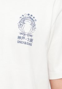 Βάτραχος με καπέλο μανιταριού που κάθεται σταυροπόδι, περιτριγυρισμένος από μανιτάρια και φάσεις της σελήνης, με ιαπωνικό κείμενο και "ONLY & SONS" από κάτω.