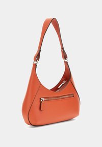 Pomarańczowa skórzana torba na ramię o zaokrąglonym kształcie, z jedną rączką i przednią kieszenią na zamek. Posiada gładką fakturę oraz kontrastujące czarne wykończenia.