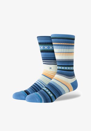 Chaussettes rayées aux tons bleu, vert et orange. Texture côtelée avec des rayures de largeurs variées. Sections renforcées au niveau des orteils et du talon.