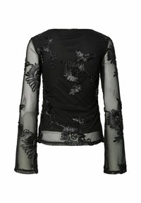 Sort, gjennomsiktig langermet topp med intrikat svart blomsterbroderi. Flatt halsutringning og klokkede ermer med en jevn tekstur.