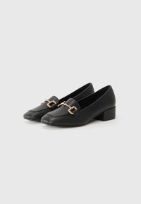 Black leather loafers with a square toe, gold chain accent, and a low block heel. Smooth texture with minimalistic design.