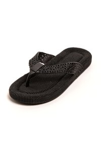 Chancla negra de goma texturizada. Presenta una tira de dedo perforada y una suela ligeramente elevada y acolchada.