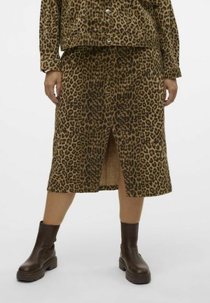 Jupe en imprimé léopard beige et noir, longueur genoux avec une fente sur le devant. Associée à des bottes de cheville marron foncé. Texture lisse, design décontracté.