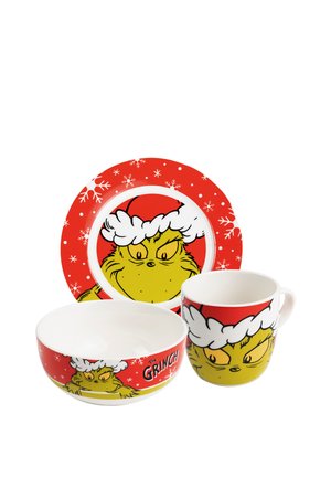 Red and white plate, bowl, and mug set featuring the Grinch wearing a Santa hat with snowflake designs on the red background.