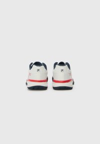 White and navy tennis shoes with red accents. Mesh upper, padded collar, and textured sole for grip. Logo on heel.