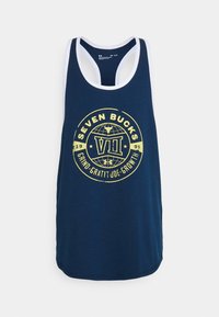 Granatowy top bez rękawów z białym wykończeniem, z żółtym okrągłym grafikiem z napisem "Seven Bucks" oraz "Grind. Gratitude. Growth" na środku.