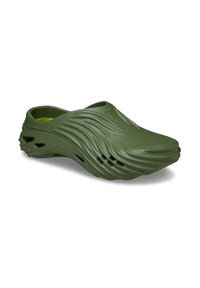 Oliwkowe klapki z gumy slip-on z falistą teksturą i wentylacyjnymi otworami po bokach i z przodu.