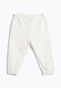 Pantalones de algodón blancos y suaves con cintura elástica y puños fruncidos en los tobillos. Diseño sencillo con una textura suave. Sin bolsillos.