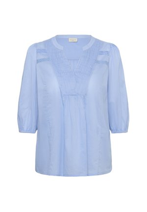Világoskék blúz sima anyagból. V-nyakkivágással, szegődött részletekkel és háromnegyedes puffos ujjakkal rendelkezik. Laza szabású.