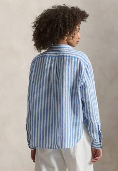 Μπλε και λευκό πουκάμισο με ρίγες, κατασκευασμένο από ελαφρύ ύφασμα, με μακριά μανίκια, καμπύλη στρόγγυλη γραμμή στο τελείωμα και λεπτομέρεια πλαϊνής ραφής στην πλάτη.