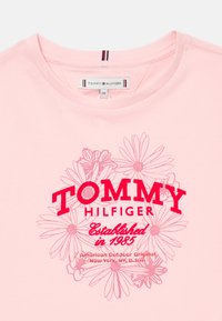 Ροζ πουκάμισο Tommy Hilfiger με λουλουδάτο σχέδιο και κείμενο "Ιδρύθηκε το 1985, Αμερικανικό Υπαίθριο Πρωτότυπο, Νέα Υόρκη, ΝΥ, Η.Π.Α."