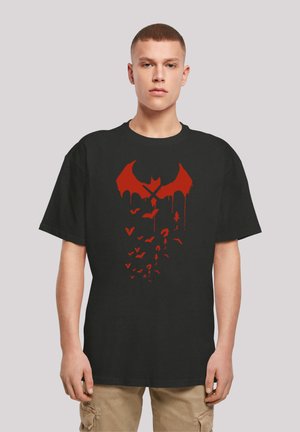 Black cotton T-shirt featuring a red bat design with dripping accents and scattered smaller bats, creating a bold graphic effect.