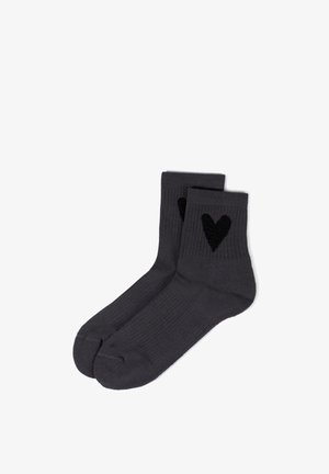 Paar dunkelgraue Knöchelsocken mit schwarzen Herzmotiven an den Seiten, gerippte Textur und verstärkte Zehen- und Fersenbereiche.