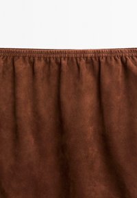 Braunes Wildledergewebe mit einem gerafften elastischen Taillenbund. Die Textur ist weich und glatt, mit einem matten Finish.