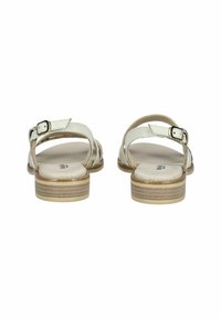 White leather sandals with a buckle strap, open back, and layered light-colored sole. Textured insole and minimalistic design.