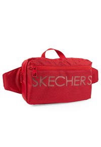 Riñonera de tela roja con un bolsillo frontal con cremallera, correa ajustable y gran logo "SKECHERS" en el lateral. Textura suave con diseño estructurado.