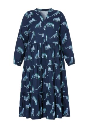 Marineblå langærmet kjole med lag og V-hals, med et gentaget mønster af hvide og blågrønne plettede leoparder i forskellige positurer.