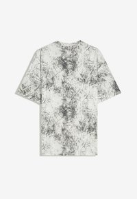 Weißes T-Shirt mit kurzen Ärmeln und einem schwarzen abstrakten, rissigen und verschmierten Muster, das den Stoff gleichmäßig bedeckt.