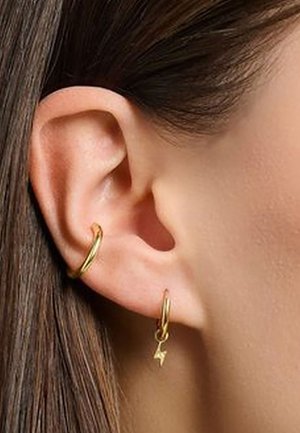 Close-up of a left ear with straight brown hair, wearing two gold hoop earrings, one with a small lightning bolt charm.