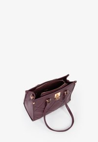 Bolso acolchado burdeos con herrajes dorados, doble asa superior y cierre con cremallera. El interior incluye múltiples compartimentos.
