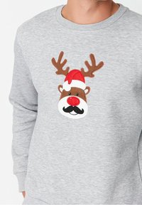 Sudadera gris con un rostro de reno bordado que tiene una nariz roja, cuernos marrones y un gorro de Santa. Tejido suave con cuello acanalado.