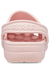 Ciabatte Crocs rosa con superficie testurizzata, due fasce larghe e una fascia al tallone sul retro. Presentano fori di ventilazione e una suola imbottita.